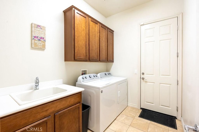 washroom with light tile patterned flooring, cabinets, washer and clothes dryer, and sink