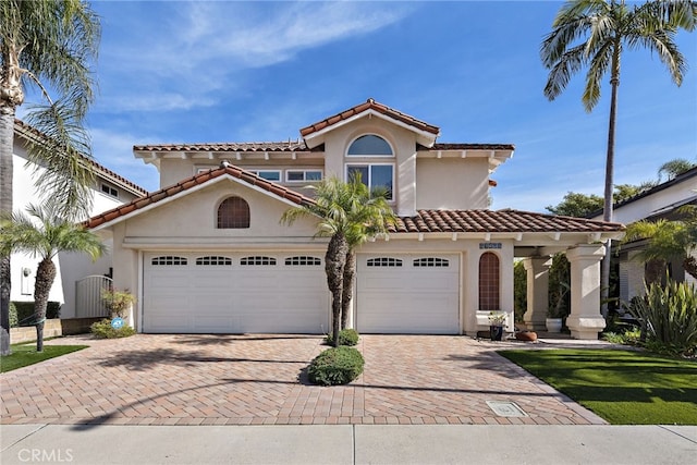 mediterranean / spanish home featuring a garage