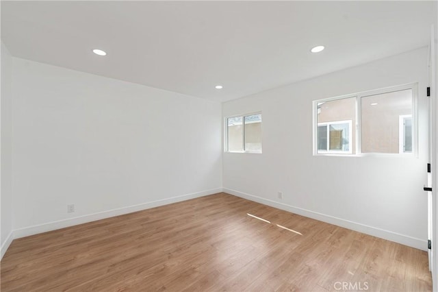 spare room with recessed lighting, baseboards, and light wood finished floors