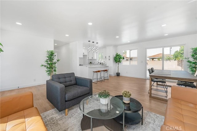 living area featuring recessed lighting, light wood-style flooring, and baseboards