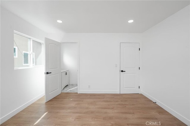 unfurnished room featuring light wood finished floors, recessed lighting, and baseboards