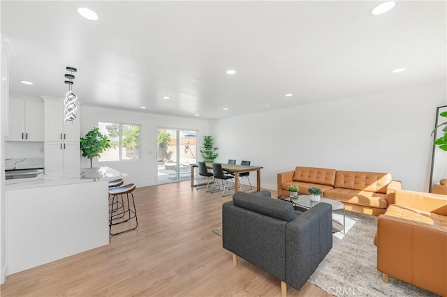 living room featuring light wood-style floors, recessed lighting, and baseboards