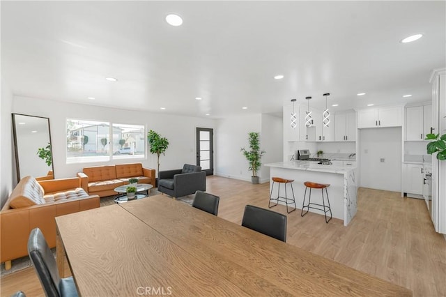 dining room featuring baseboards, light wood-style flooring, and recessed lighting