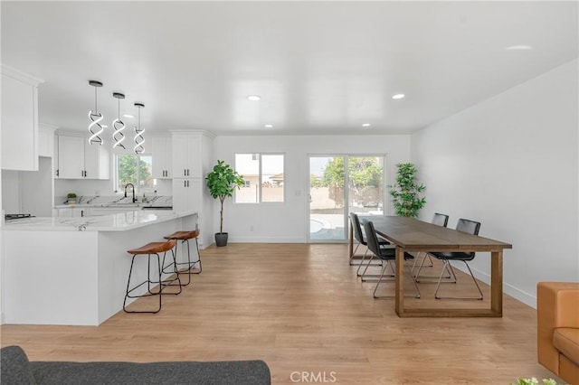 dining space featuring recessed lighting, baseboards, and light wood finished floors