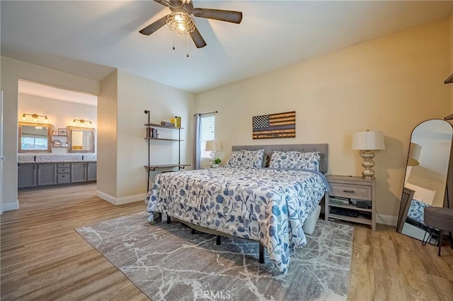 bedroom featuring ceiling fan, light hardwood / wood-style floors, and ensuite bathroom