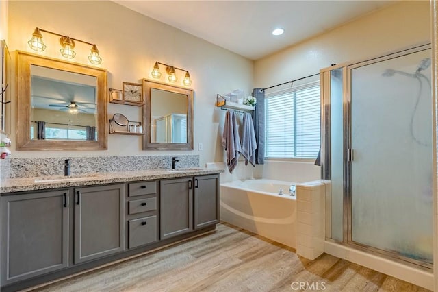 bathroom with hardwood / wood-style flooring, ceiling fan, vanity, and independent shower and bath