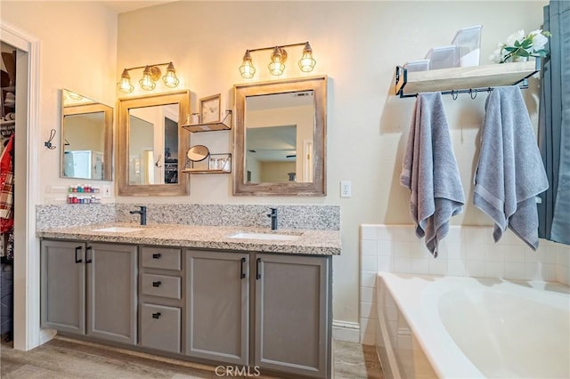 bathroom with hardwood / wood-style flooring, vanity, and a tub