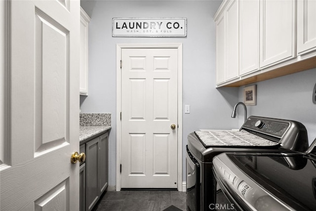 washroom featuring separate washer and dryer and cabinet space