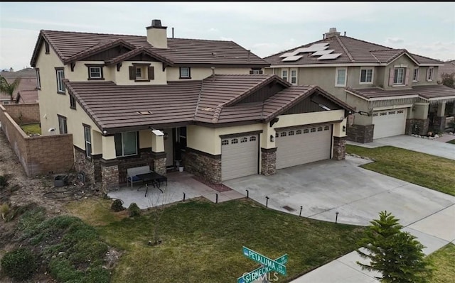 view of front of home featuring stone siding, a front lawn, concrete driveway, and stucco siding