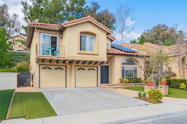 mediterranean / spanish-style house featuring solar panels, a garage, and a balcony