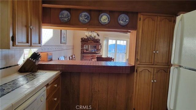 1239 Yosemite Dr, Lake Arrowhead, CA 92352 - kitchen featuring tile counters, white appliances, backsplash, and brown cabinetry