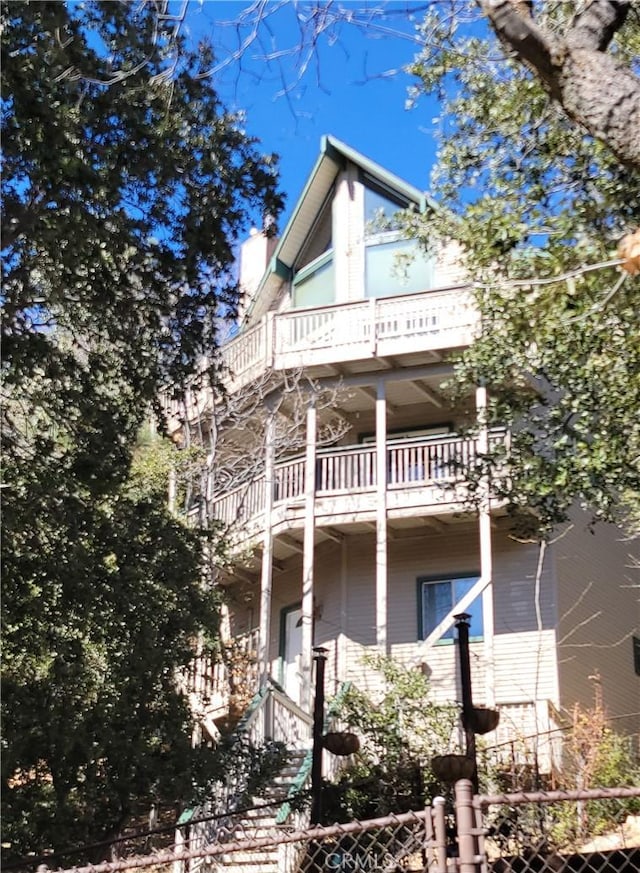 view of side of home with a chimney and fence