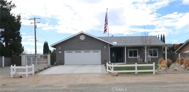 ranch-style home with a fenced front yard, concrete driveway, an attached garage, and stucco siding