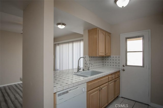 kitchen with tile countertops, sink, white dishwasher, light brown cabinetry, and decorative backsplash