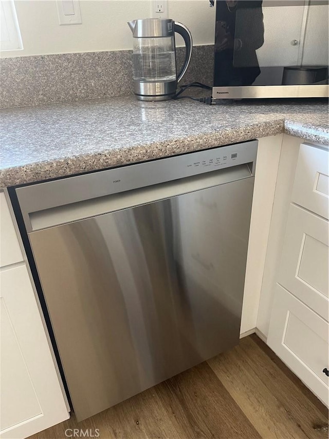 room details with hardwood / wood-style floors, stainless steel appliances, and light stone counters