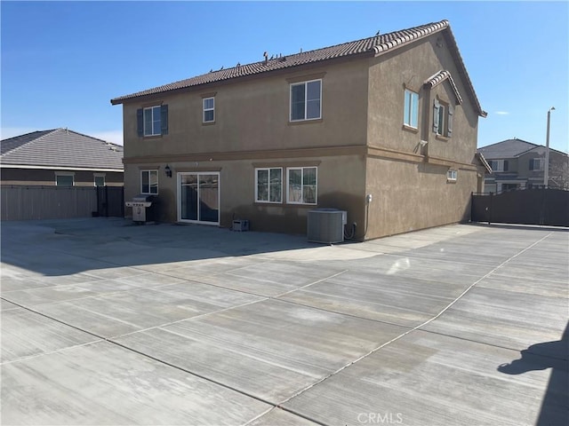 rear view of house featuring cooling unit and a patio area