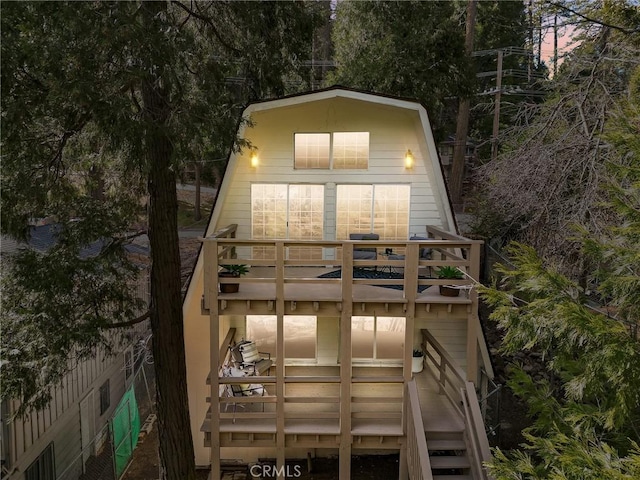 back house at dusk featuring a balcony