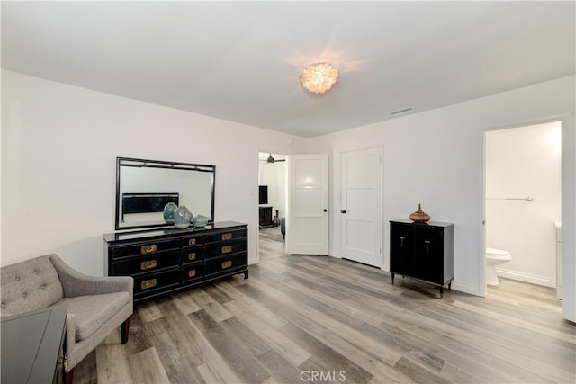 sitting room featuring light wood-type flooring, visible vents, and baseboards