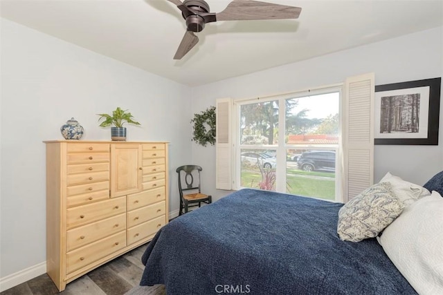 bedroom with a ceiling fan, dark wood finished floors, and baseboards