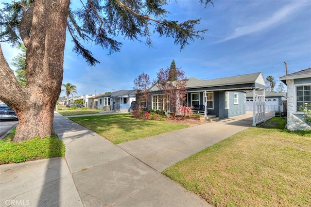 view of front of home with a front yard, fence, and a residential view