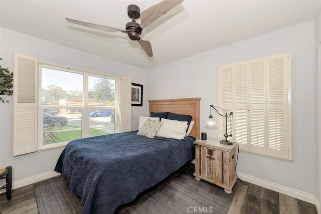 bedroom featuring dark wood-type flooring, baseboards, and a ceiling fan