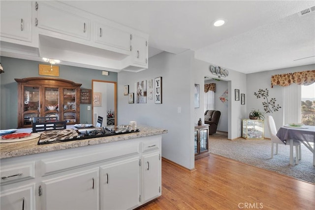 kitchen with white cabinetry, black gas stovetop, and light wood-type flooring