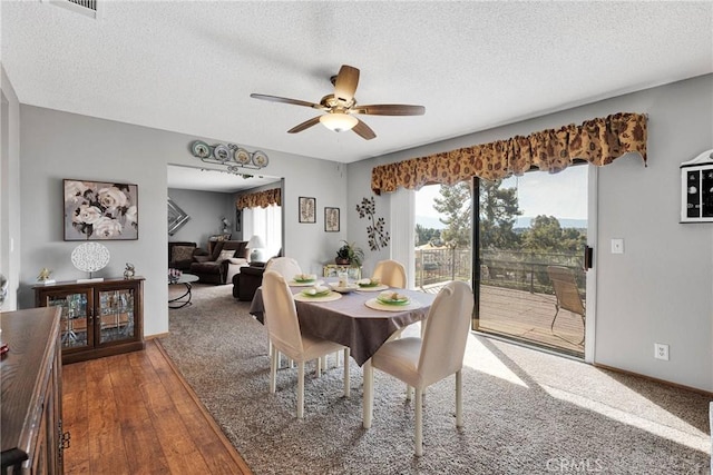 dining space featuring hardwood / wood-style floors, ceiling fan, and a textured ceiling