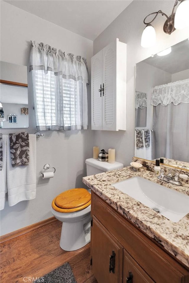 bathroom with hardwood / wood-style flooring, vanity, and toilet