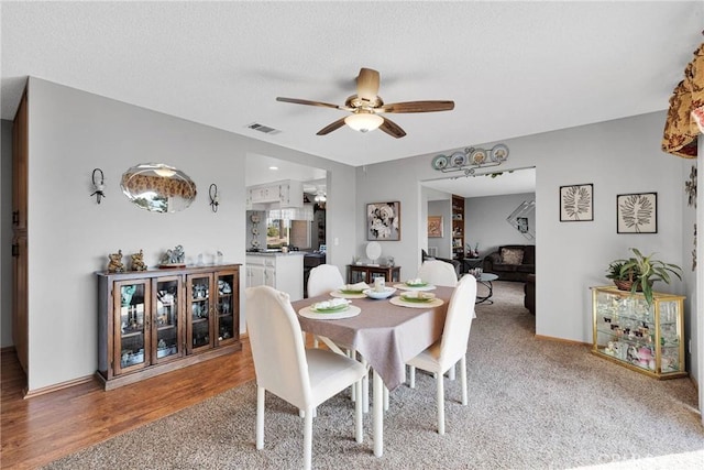 dining space with hardwood / wood-style flooring, ceiling fan, and a textured ceiling