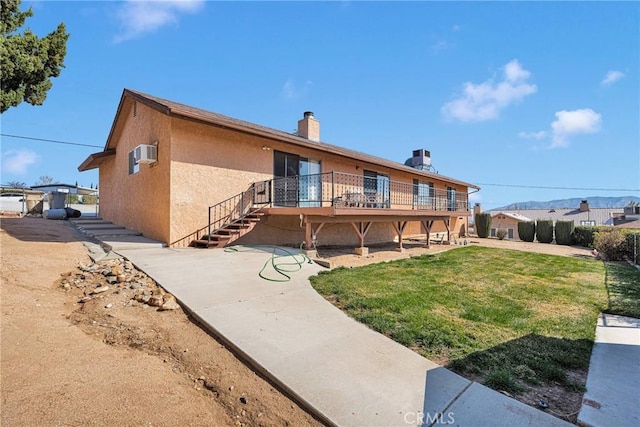 back of house featuring an AC wall unit, a deck, and a lawn