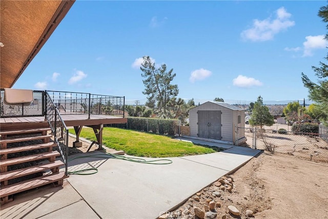 view of yard featuring a shed, a patio, and a wooden deck