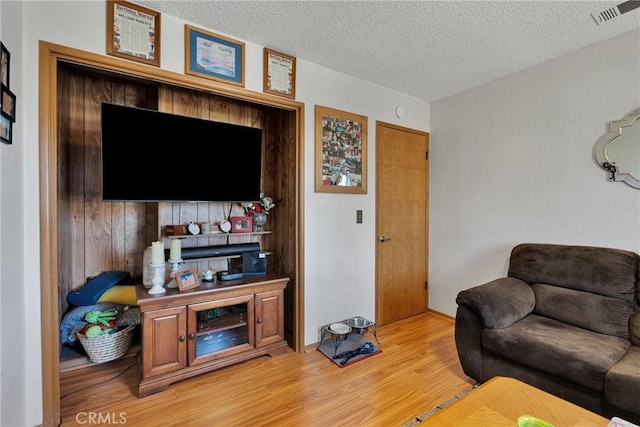 living room with a textured ceiling and hardwood / wood-style floors