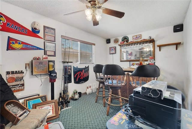 carpeted office featuring ceiling fan and a textured ceiling