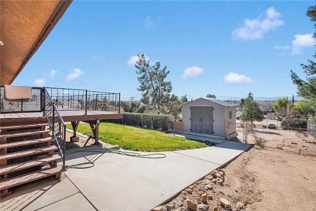 view of yard with a patio area, a deck, and a storage shed