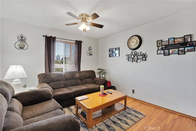 living room featuring a textured ceiling, ceiling fan, and wood-type flooring