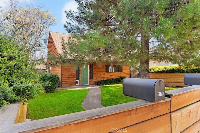 view of front of property with a front yard and fence