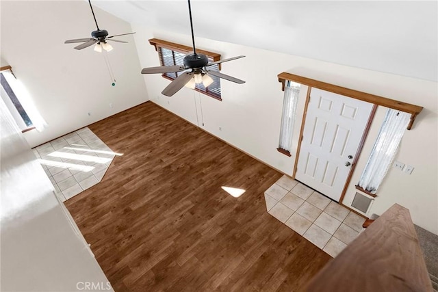 foyer entrance with ceiling fan, wood finished floors, and vaulted ceiling