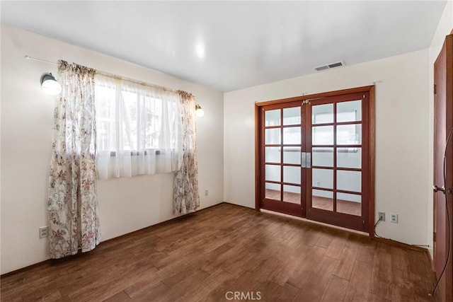empty room with french doors, wood finished floors, and visible vents