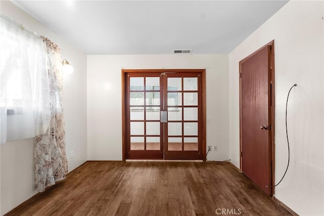 doorway to outside with visible vents, wood finished floors, and french doors