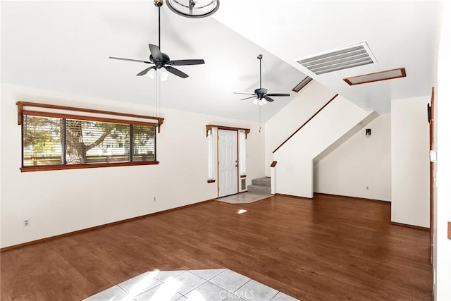 unfurnished living room featuring stairway, a ceiling fan, wood finished floors, lofted ceiling, and visible vents