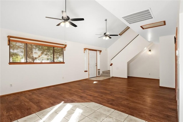 interior space with attic access, visible vents, lofted ceiling, wood finished floors, and stairs