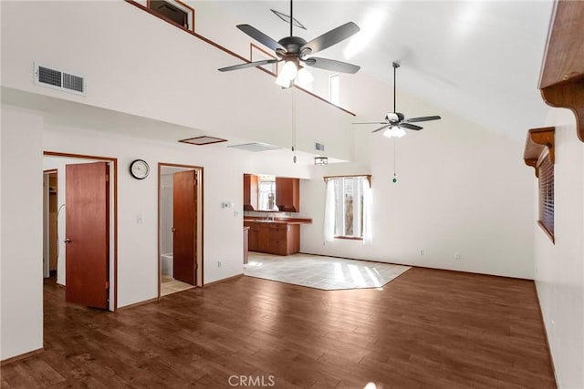 unfurnished living room featuring light wood-type flooring, high vaulted ceiling, visible vents, and a ceiling fan