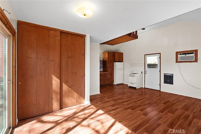 interior space with lofted ceiling, wood finished floors, and an AC wall unit