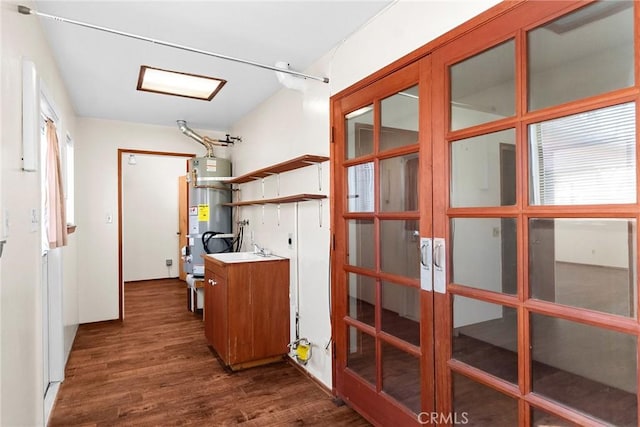 interior space with dark wood-style flooring, open shelves, french doors, and gas water heater