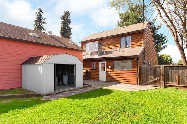 back of property with an outbuilding, a gate, fence, a storage unit, and a yard