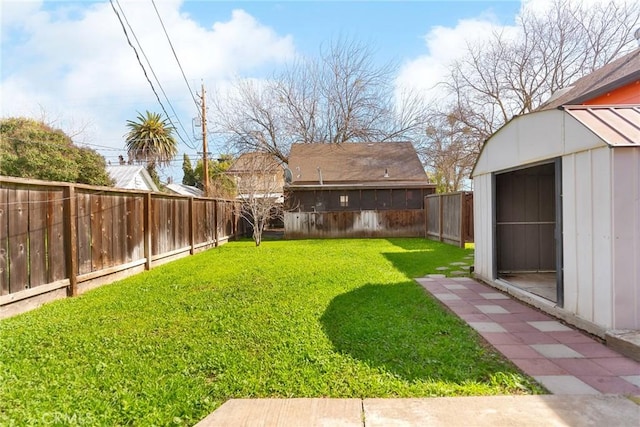 view of yard with an outdoor structure, a fenced backyard, and a shed