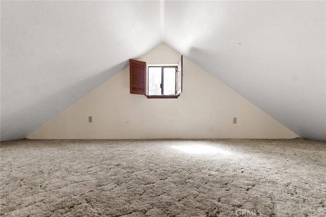 additional living space featuring lofted ceiling and carpet