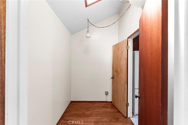 hall with lofted ceiling and wood finished floors