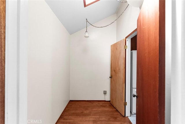 corridor featuring lofted ceiling and wood finished floors
