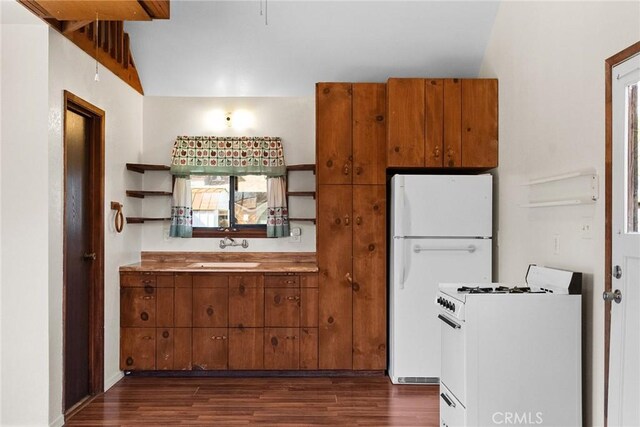 kitchen featuring white appliances, brown cabinetry, a sink, and open shelves